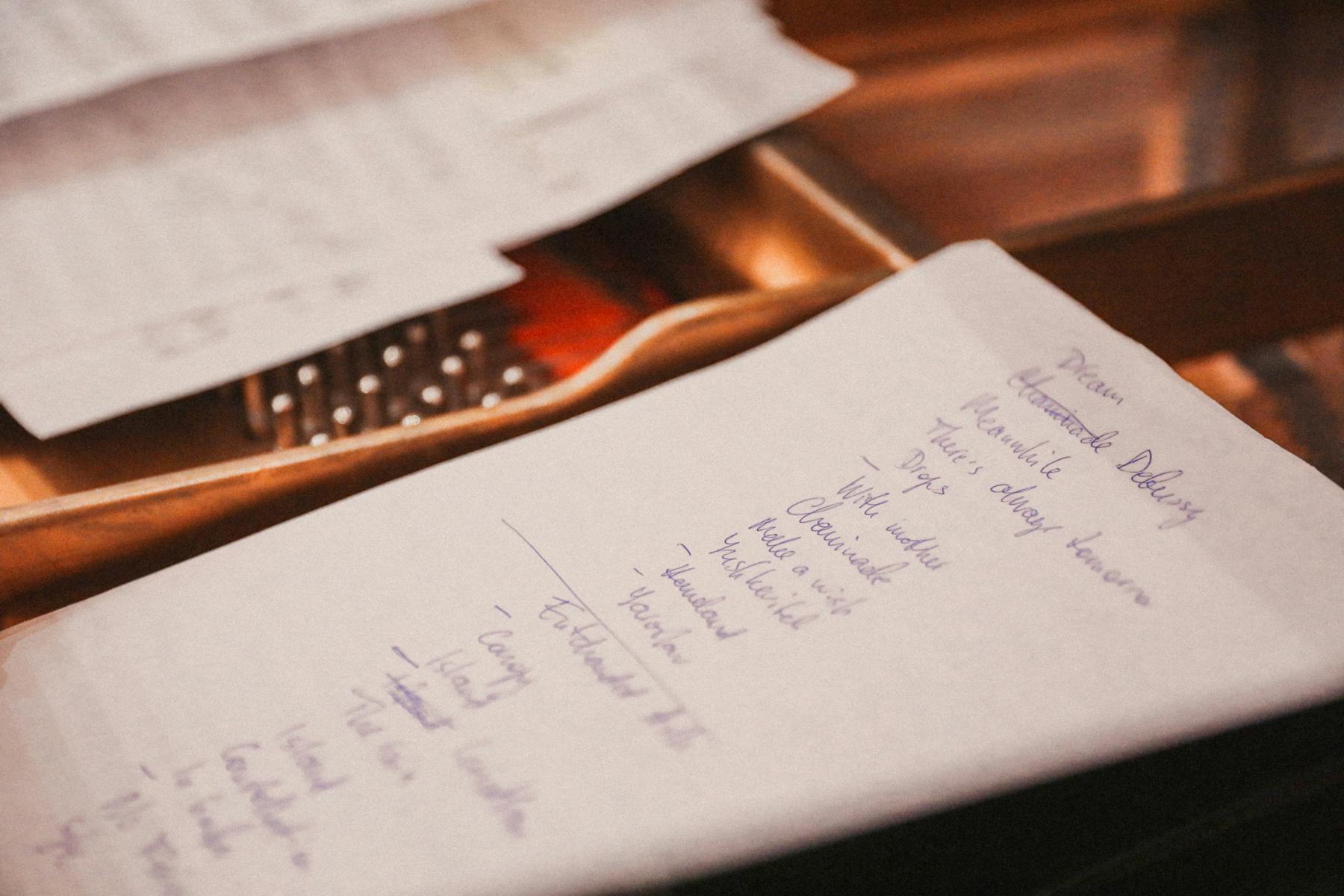 A handwritten checklist and budget notes spread across a desk